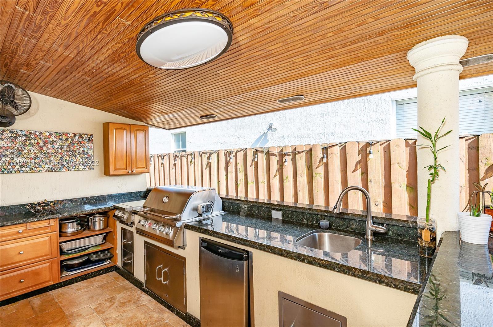 Fabulous  spacious Summer Kitchen, with all the gadgets: BBQ, burners, refrigerator, sink and bar counter.