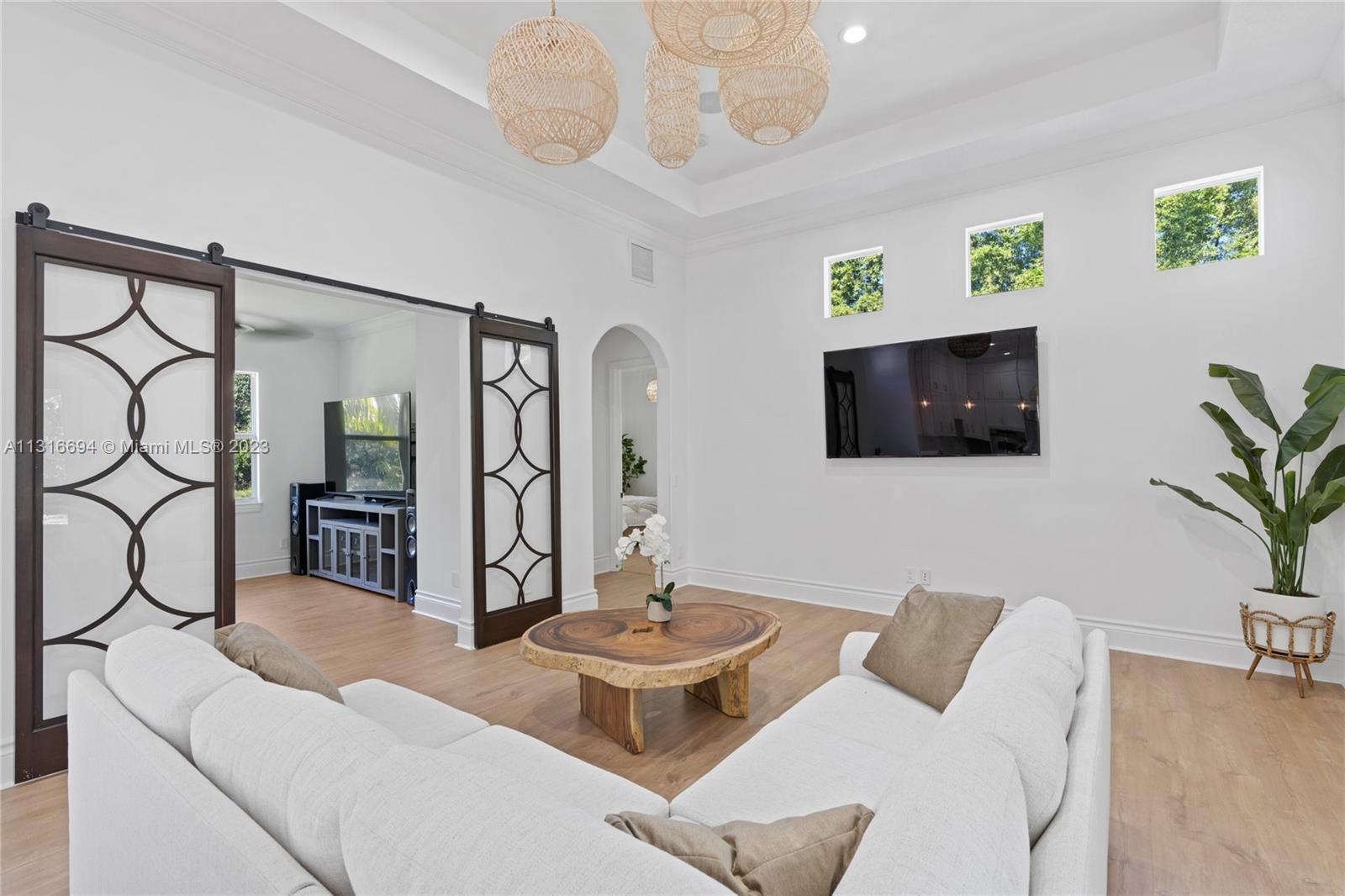 In one wing of the house you will open the stunning glass barn doors into a bright den.