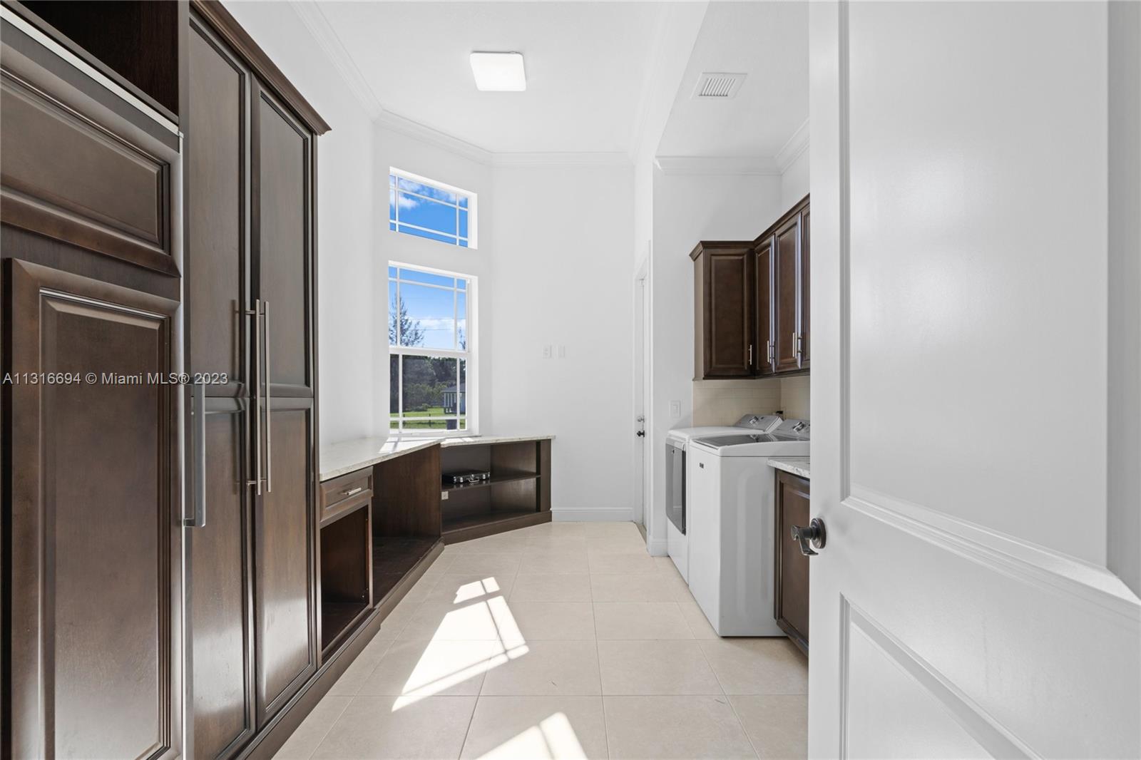 A large laundry room with custom made cabinets and a sub-zero freezer