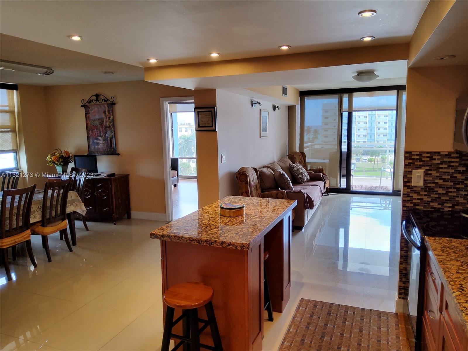 Kitchen area looking to den and balcony