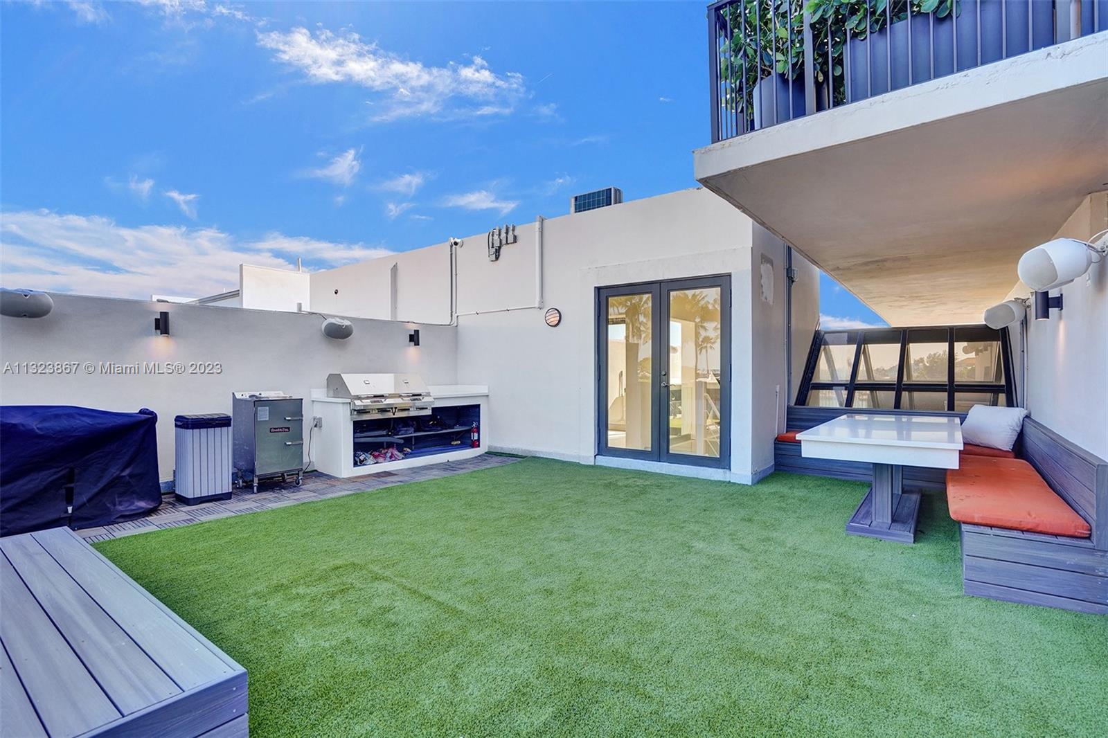 2nd rooftop on 4th floor with BBQ grill. Top of the line astroturf with teal accents and quartz white carrera dinning table