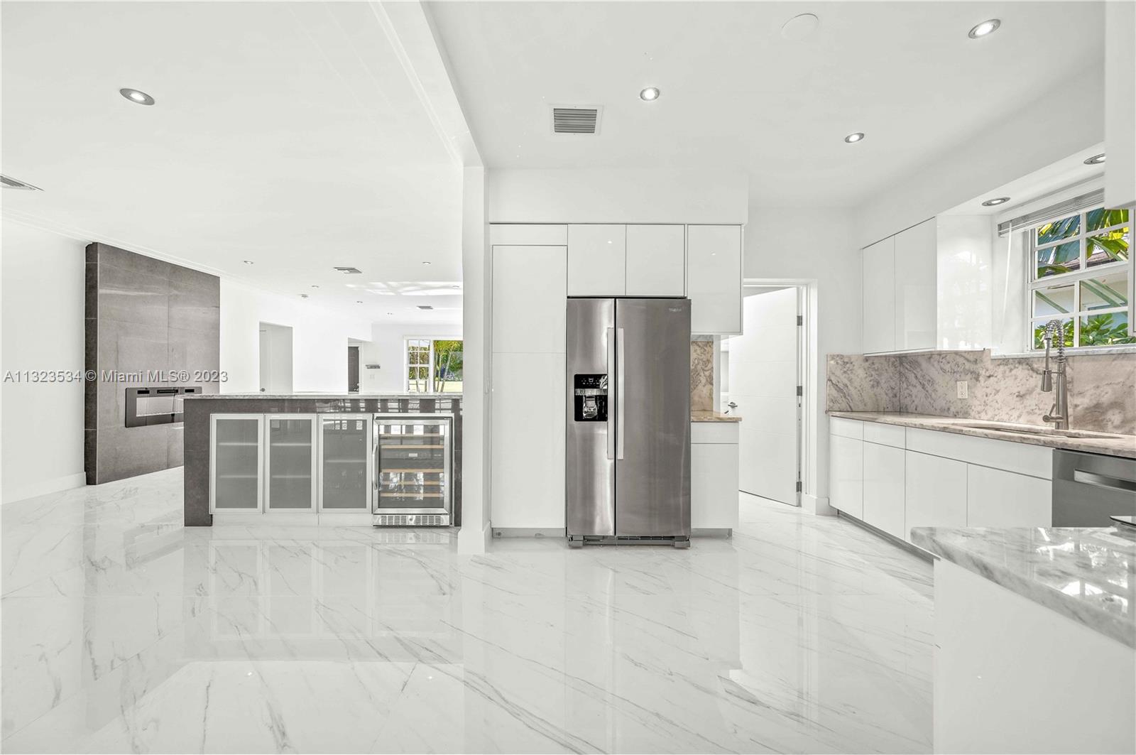 the kitchen, the island with wine cooler and the decorative fireplace