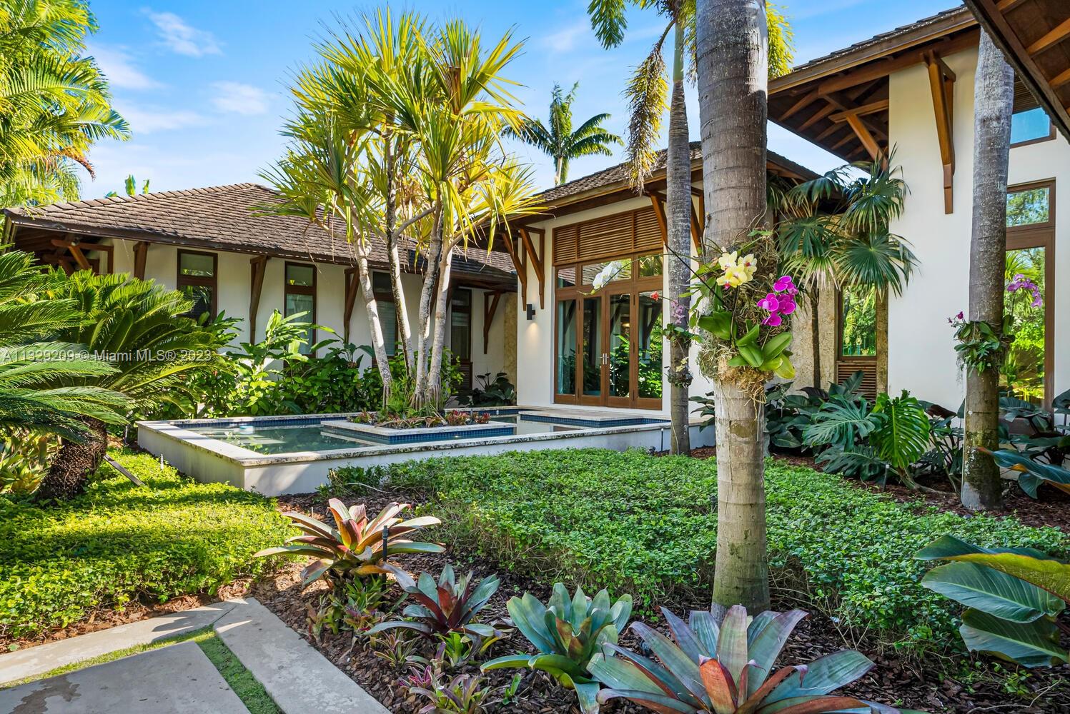 Arrive at this gated sanctuary & onto its lush tropical landscaped grounds surrounding the true essence of resort-style living. Built in 2015 by renowned architect Cesar Molina of CMA Design Studio.  He was commissioned to design this tropical Bali modern family residence with 5 bedrooms/6-1/2 baths. Features include various pavilions/outdoor living spaces, 16-foot high ceilings, Cumaru wood in overhang & linear slat finishes. Native Oolite stone provides a natural warm feeling to its architecture. Additional details include total of 7,685 sq.ft., full house generator, backyard putting green, summer kitchen, water features/coral rock pavers/columns.This home is ideal for family gatherings while providing ample indoor/outdoor spaces for a recreational and relaxing living experience.
