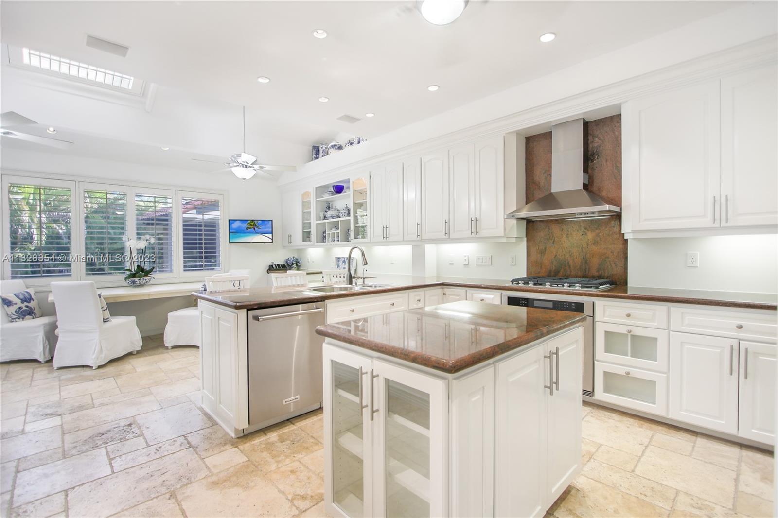 Beautiful 400-sq. ft. eat-in island kitchen and separate dining and study area, walk-in pantry, skylights, custom wood cabinets, new KitchenAid gas stove and ovens, SubZero fridge, opens to covered terrace with barbeque