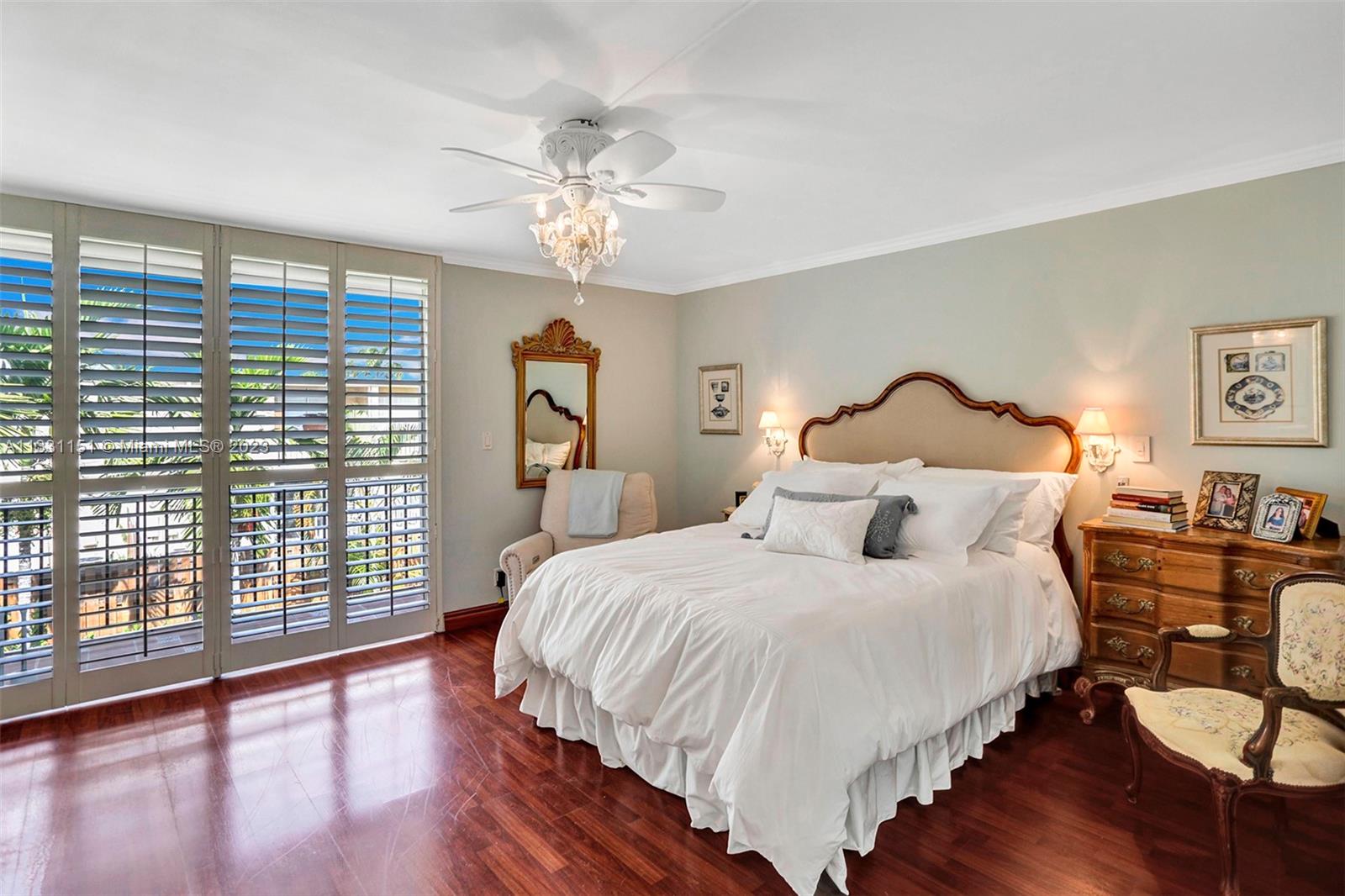 Primary bedroom with balcony access, en-suite bathroom, all wood plantation shutters/ high impact glass sliding doors