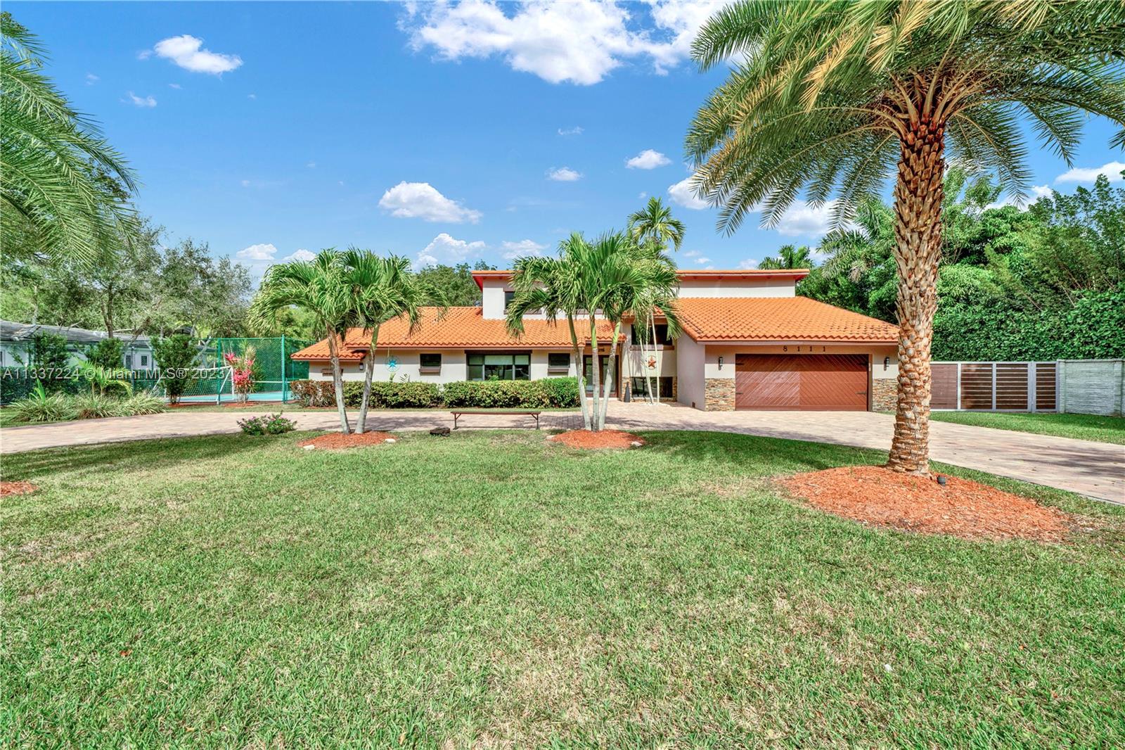 Live /Play here all that you need 4 bed 3.5 bath home with formal dinning, spacious living area with lots of natural light, charming open wood beam ceiling, within a serene space in a quiet palmetto bay. A bright and airy kitchen that has been enhanced with new modern kitchen cabinets, granite counter tops, an island bar eating area with built in seating. The living room area looks over the covered tropical backyard oasis with invigorating garden, pool, tennis court that is interchangeable to a soccer field/ basketball and an outdoor kitchen with an extended patio terrace. Corner lot on a private street with circular driveway with plenty of space to park a boat/RV. All bedrooms on the main floor with an extra loft area can a game/media/bonus room+ a home office with built in murphy bed.
