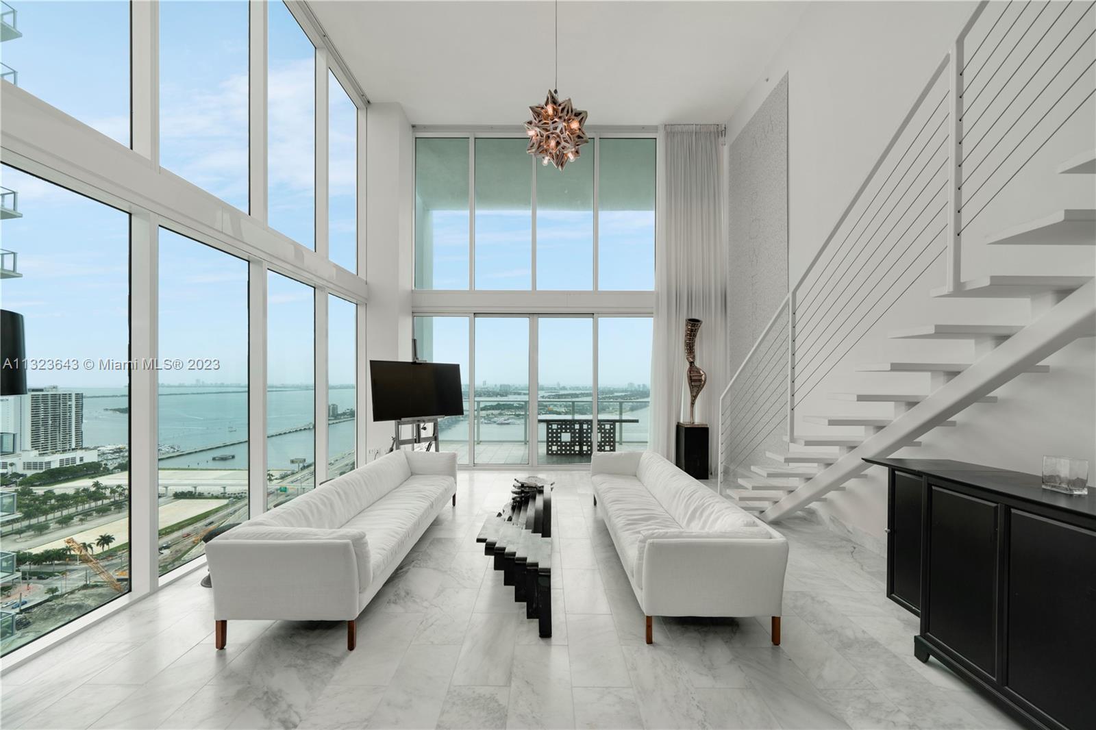 Beautiful 2-story loft at Ten Museum Park with 2 Bedrooms, 2.5 Baths, 1,730 interior square feet, Carrera white marble flooring throughout, renovated bathrooms, stainless steel kitchen appliances, and 20-foot-high ceilings overlooking the park and Biscayne Bay. Includes 2 parking spaces. Building amenities include swimming pools, hot tub, fitness center, spa, 24-hour valet parking service, and 24-hour concierge.