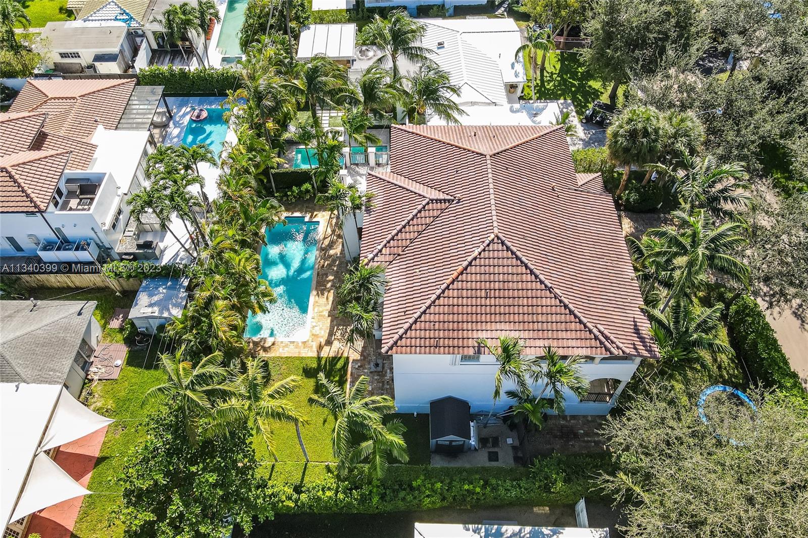 This wonderful elevated home has a fantastic layout with 5 Bedrooms plus an Office, 4/1 Baths and high ceilings. First floor consists of an ample foyer with formal dining and living room area, one Bedroom next to a full cabana bathroom, plus an Office and a powder room. Separated large family room, open kitchen and a very comfortable breakfast area filled with natural light. Second floor features a total of 4 Bedrooms and 3 Bathrooms (one of them is a Jack and Jill bathroom) with a very ample master suite with private terrace. Third covered terrace is a bonus: ideal to use as a gym, game area or another gathering area. Enjoy your spectacular pool with a very ample garden on the side, manicured landscaping with elegant palm trees, located steps from the Village Green.
