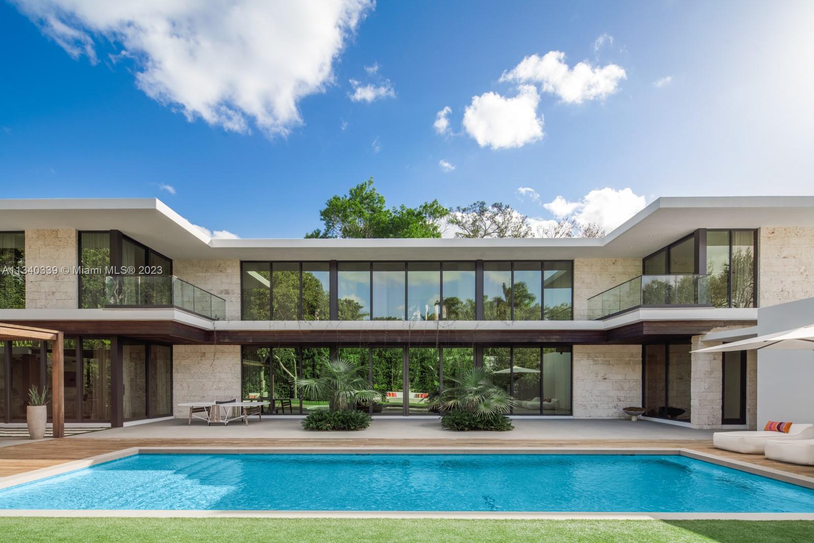 This contemporary residence, designed by the preeminent subtropical modernist architect Max Strang and completed in 2020 in the guard-gated community of Hammock Lakes, takes advantage of its surroundings and climate to embrace the true indoor-outdoor Floridian lifestyle. Inspired by midcentury architecture, with elements such as persiana louvers and deep, overhanging eves for shade, the 7,246 square-foot home offers generous spaces for entertaining on a grand scale with oversized, impact-resistant doors that recess to connect to the sprawling poolside terrace with cabana kitchen, all surrounded by lush native landscaping. Beyond is an elegant grand staircase, a formal dining room, seven bedrooms, a lavish master suite, a two-car garage, and an additional double carport off the main entry.
