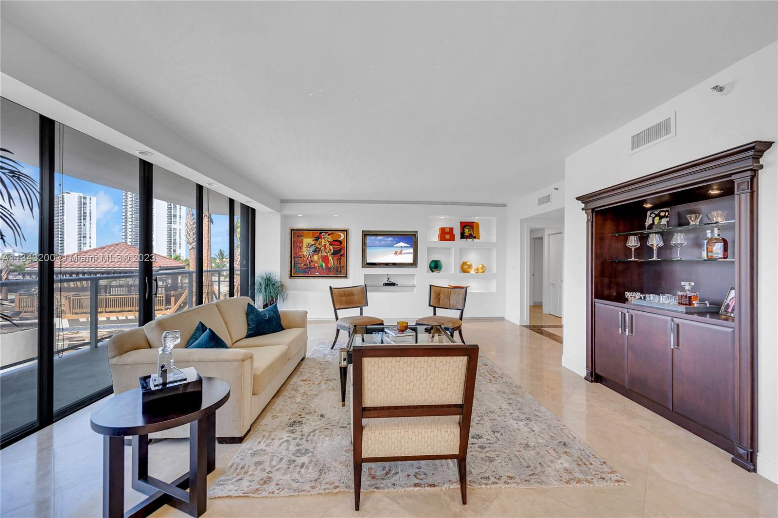 Living room with partial view of pool area and cabanas currently being remodeled.