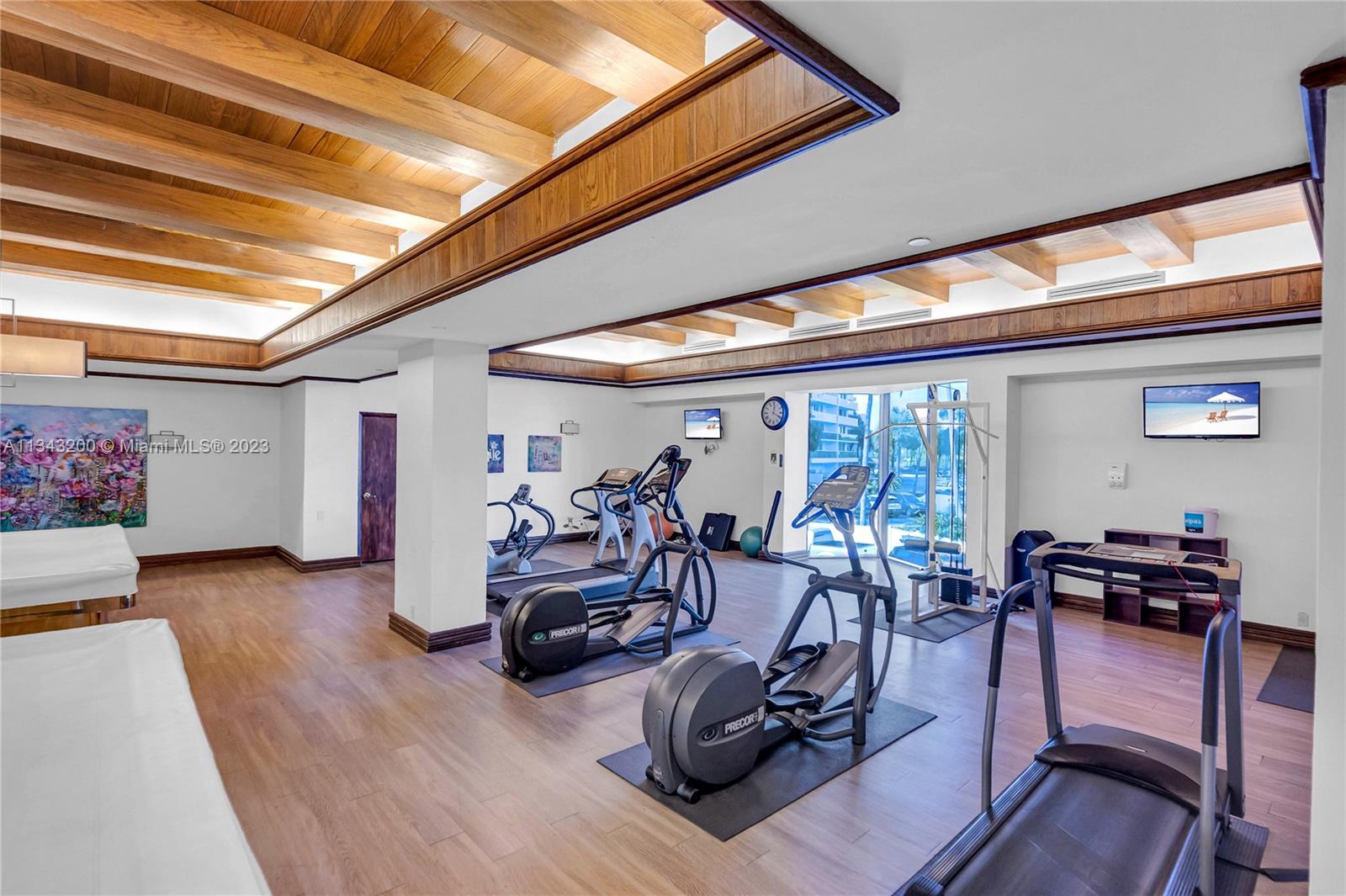 Enterntaiment room in building with exercise equipment and pool tables.
