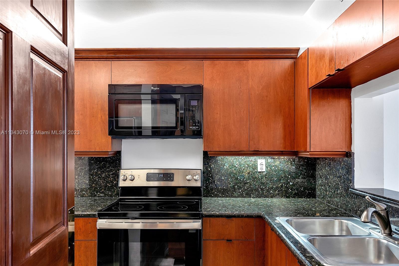 Kitchen with pass-through window and granite countertop.