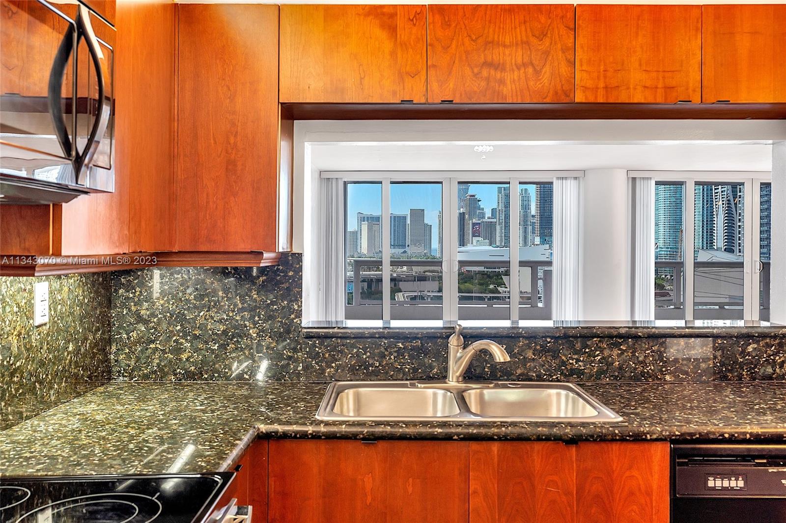 View of balcony and Downtown Miami from kitchen via passthrough window.