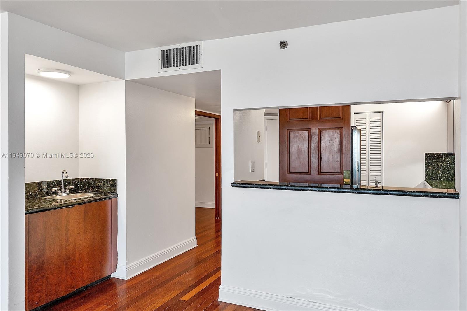 View of kitchen from dining room with wet bar to the left.