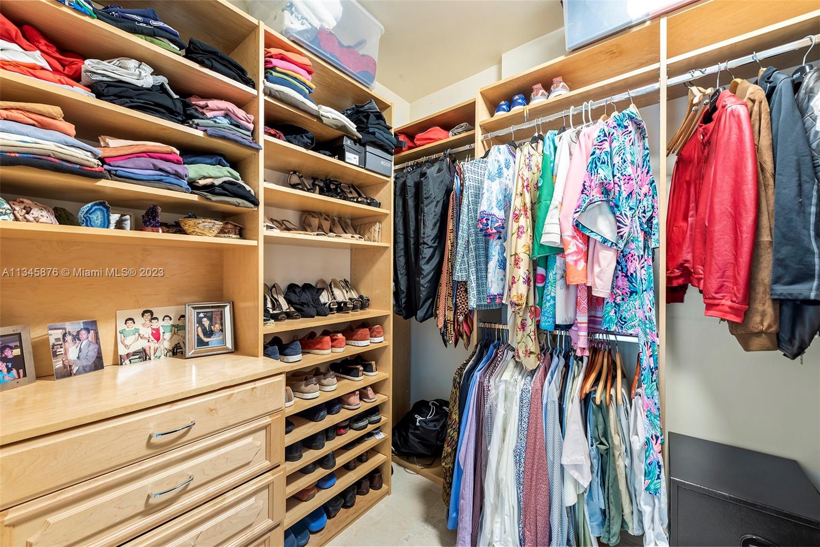 Principal bedroom closet with built-in cabinetry