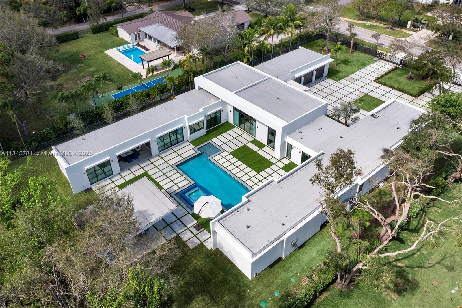 Luxury living awaits in this stunning 2022 modern estate in Pinecrest offering state-of-the-art construction and impeccable finishes. Welcomed by gorgeous water features and an open floor plan with volume ceilings and breathtaking panoramic views. This magnificent home boasts 7 bedrooms & 7/1 bathrooms of which one is a detached 1br/1ba guest house. The Italian-style chef's kitchen includes Wolf/SubZero appliances, a wet bar, butler's pantry, and glass wine gallery. The lavish master suite offers sitting area, boutique-style walk-in closets and a spa-like bath with a floating tub and rain shower. The backyard is a true oasis with a huge pool, tanning ledge, jacuzzi, covered terraces, and a summer kitchen. This remarkable estate also features a maids' room, 3-car garage, and carport for 2.
