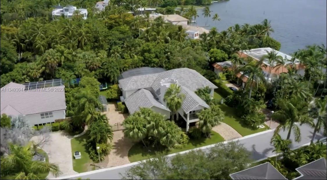 Beautiful 5/7 pool home in South Coconut Grove in prestigious  Entrada waterfront neighborhood by the bay.  Home has 5 bedrooms and 7 baths; a wet bar; a large covered porch; separate living, dining and family rooms; eat in kitchen; grand foyer with a spiral staircase in turret, sprinklers, impact windows and doors, heated pool, generator, artificial turf area. The yard is secure with concrete wall on 3 sides and electric car gate. There are 2 Master bedrooms w 2 large closets each, his and her sinks. The primary master has both shower and roman tub and a balcony with bayview. The porte-cochere over the driveway will keep you dry. Community includes a security guard, entrance gate, waterfront park and canal access (shared riparian rights) and tennis court.