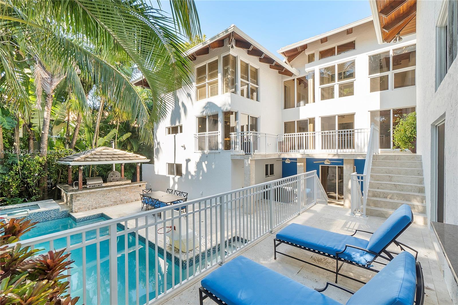 Cocoplum chic contemporary home in Coral Gables surrounded by lush tropical foliage. Cul-de-sac privacy.  Soaring interiors, floor to ceiling glass walls w/verdant & pool views. Soothing natural light makes home a tranquil enclave.  Tri-level, perfect for family privacy & entertainment: 5 ensuite bedrooms & 6.5 baths. Top floor 4 bedrooms: main bdrm w/sitting area & 2 walk-in closets, modern ensuite bath. Opposite wing 3 bdrms w/ensuite baths. Main floor has kitchen, dining room, office, 1/2 bath, living room adjacent to family room w/wet bar, opens to terrace, pool w/spa and built-in summer kitchen w/BBQ and pizza oven. On ground level, cabana bathroom, cool game room and bdrm (in-law/staff) w/ensuite bath. Privacy and security, resort-style amenities, make this house practically perfect.