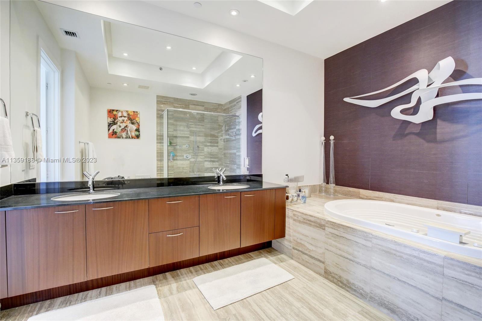 Double Sinks with black marble counters and jacuzzi