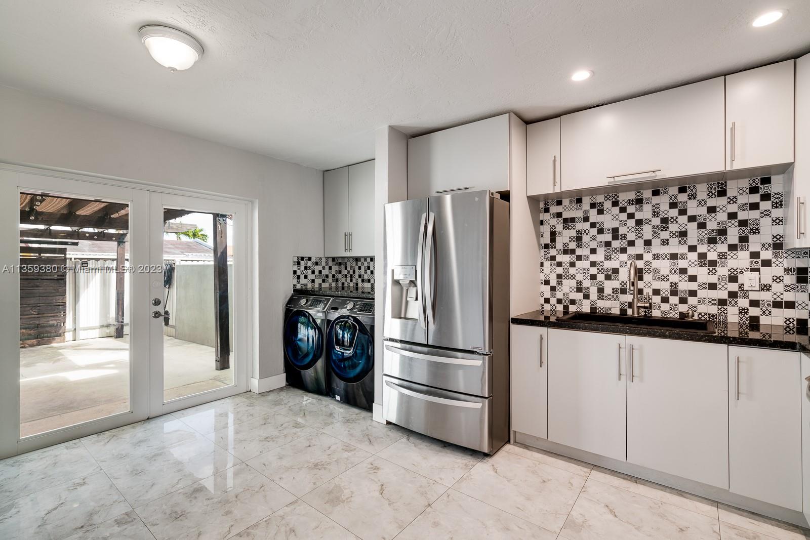 The kitchen area ( apx 14' X 12' ) and was installed apx in 2018 and has all SS LG appliances plus the washer/dryer. New Impact glass French Doors lead out to the covered patio. Notice that the wood beams that hold the canvas top to the shaded area of the patio.