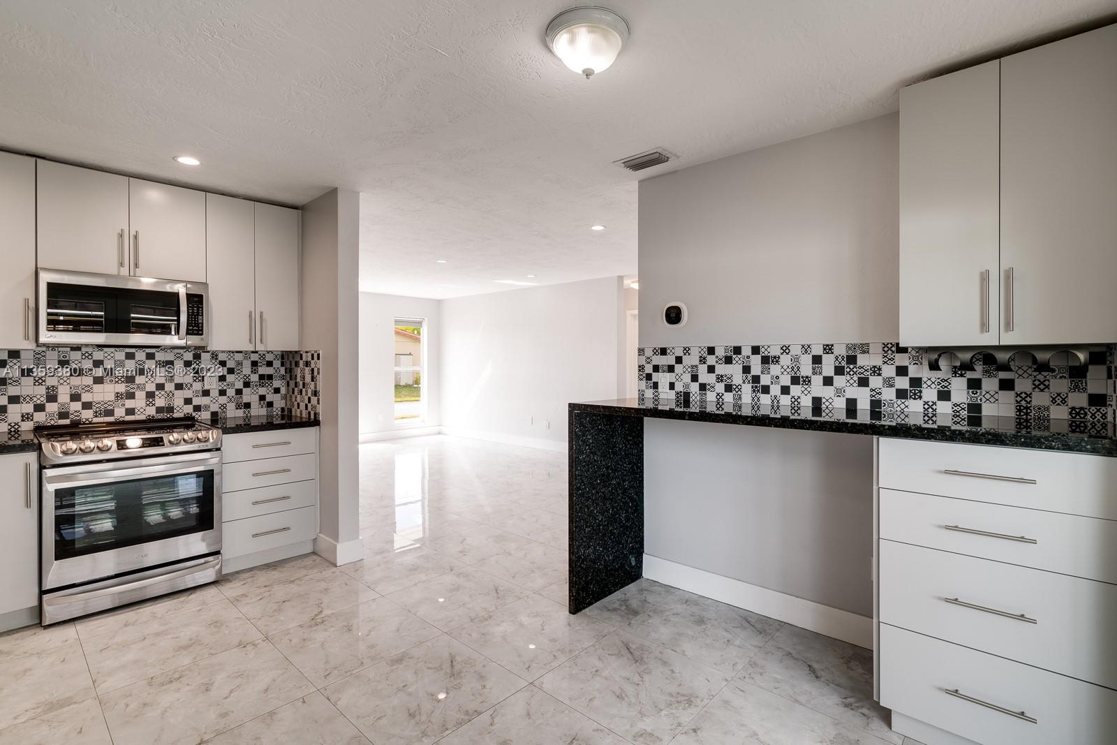 Very nice LG micro-wave, electric range and notice the counter space on the right is for Bar stools. Notice all the STORAGE SPACE that you see with all of these cabinets.