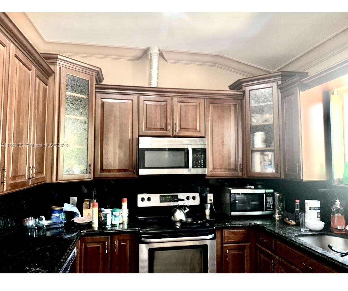 Large kitchen with wood cabinets and all stainless appliances