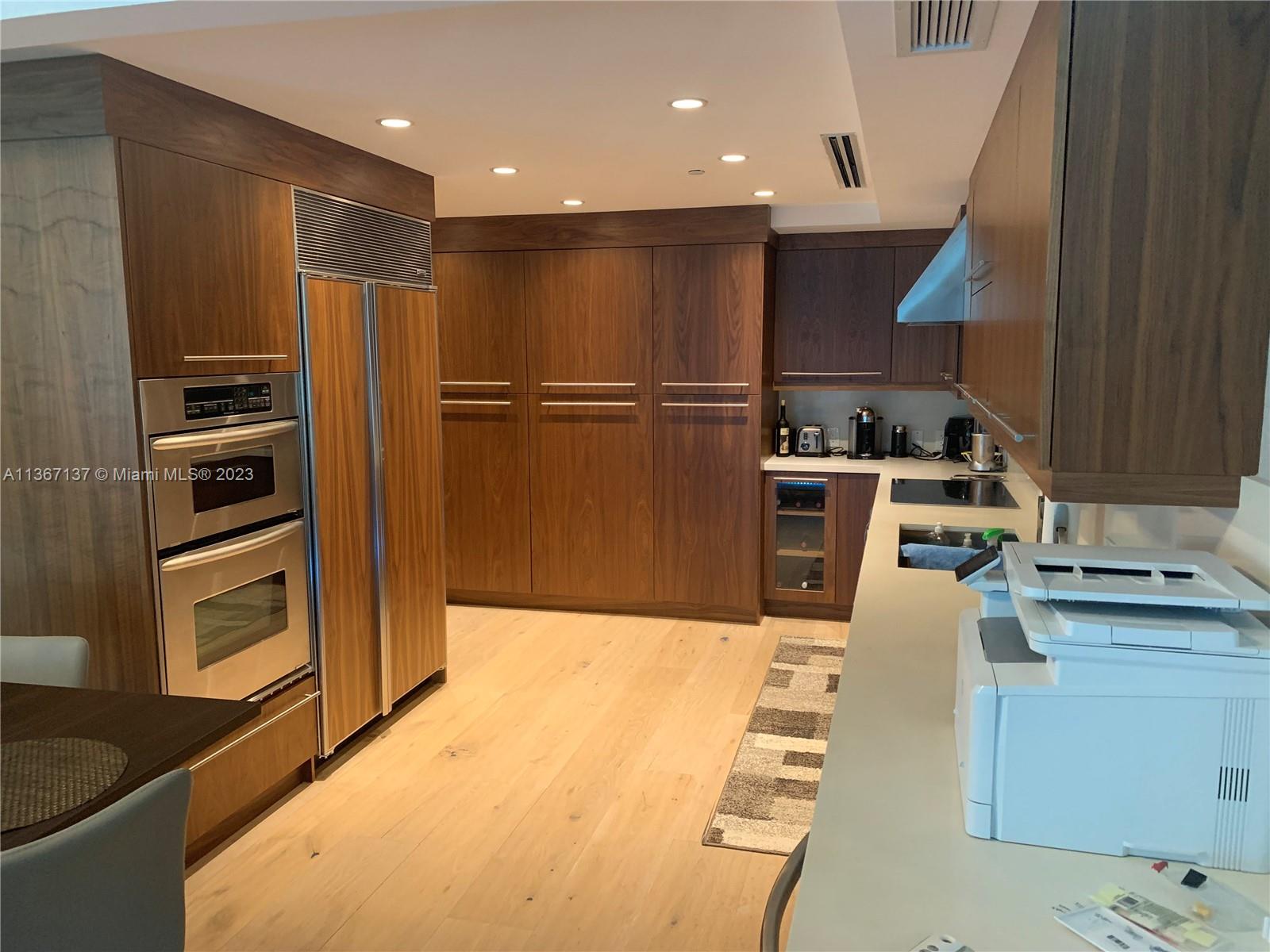 State of the art kitchen with fabulous appliances and walnut wood cabinetry, wine cooler and marble countertops.