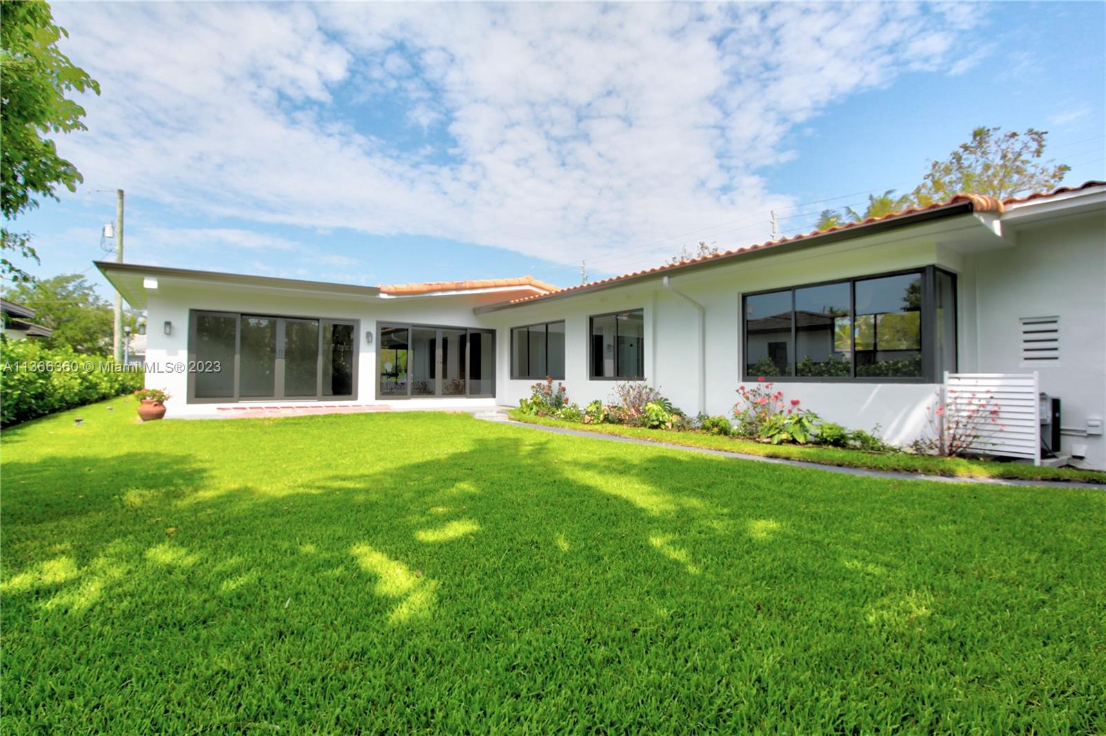 Sunny and large dining room and florida room with 24 ft open doors to lush backyard