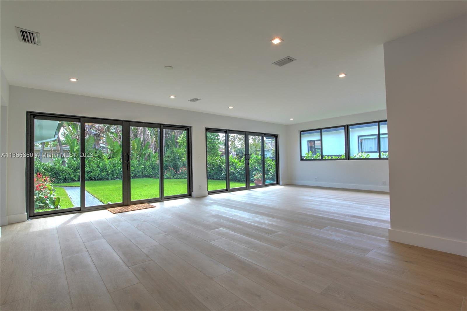 Sunny and large dining room and florida room with 24 ft open doors to lush backyard