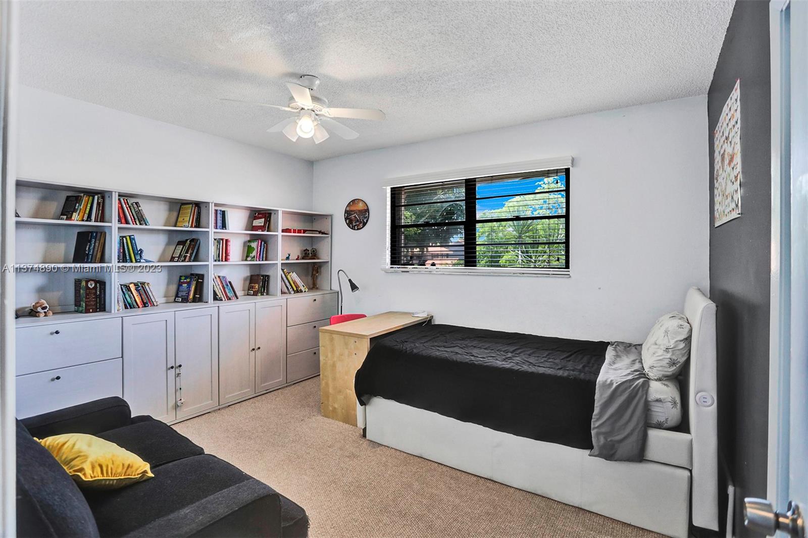 A different angle view of the bedroom with shelving & cabinetry.