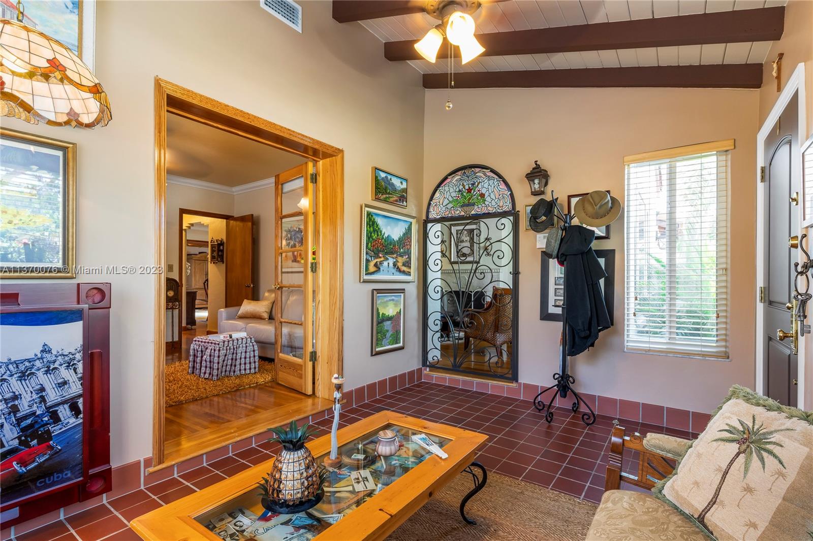 Foyer looking towards guest bedroom (currently used as lounge area) on left and living room through stained glass iron door.