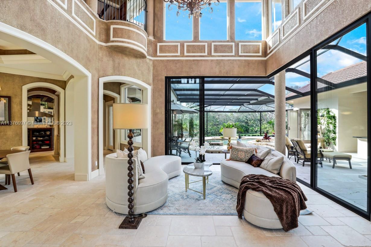 Double height reception room with sliding glass wall.