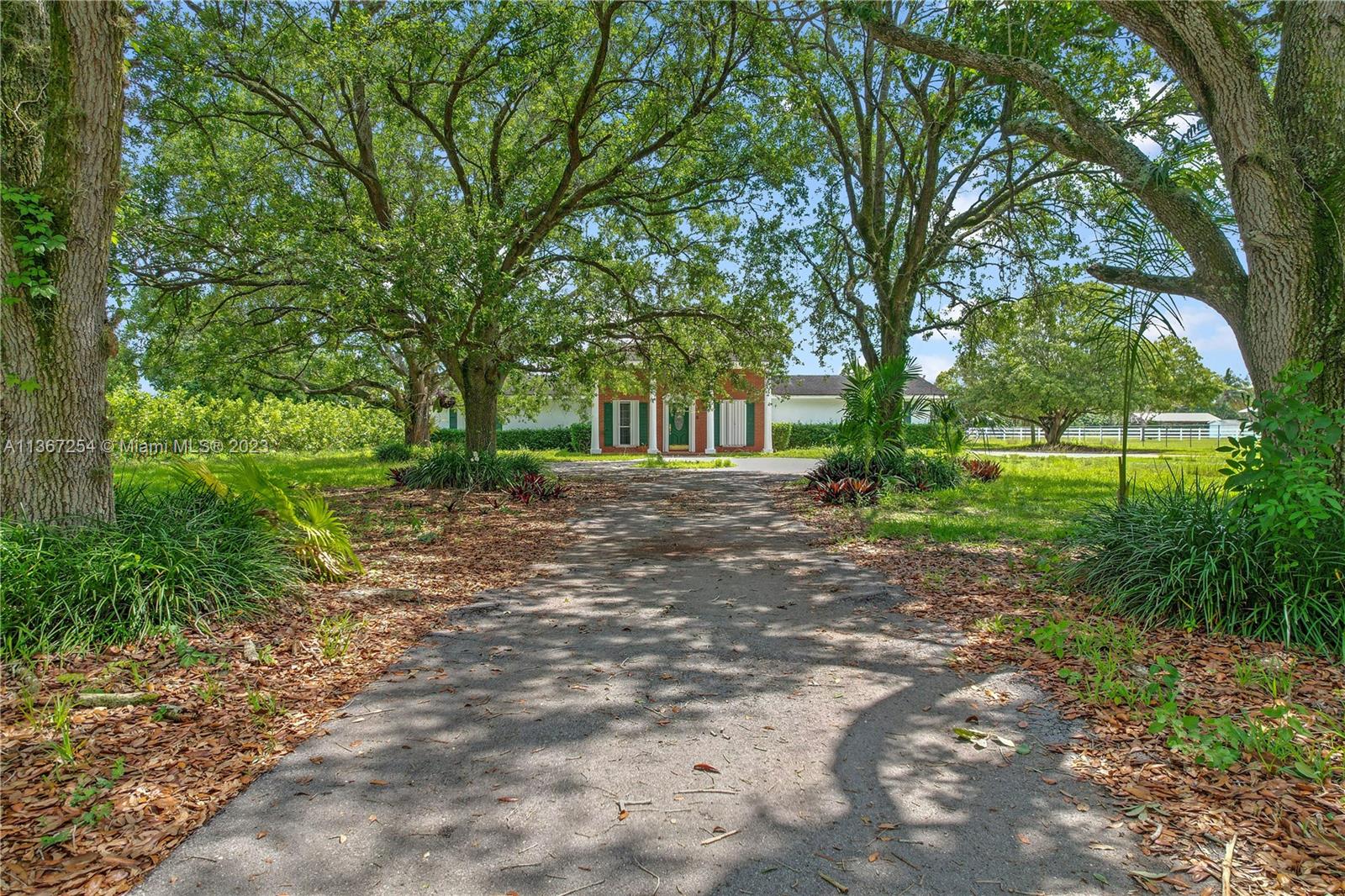 FRONT ENTANCE TO COLONIAL 3/3 POOL WITH STABLES AND GROVE HOME