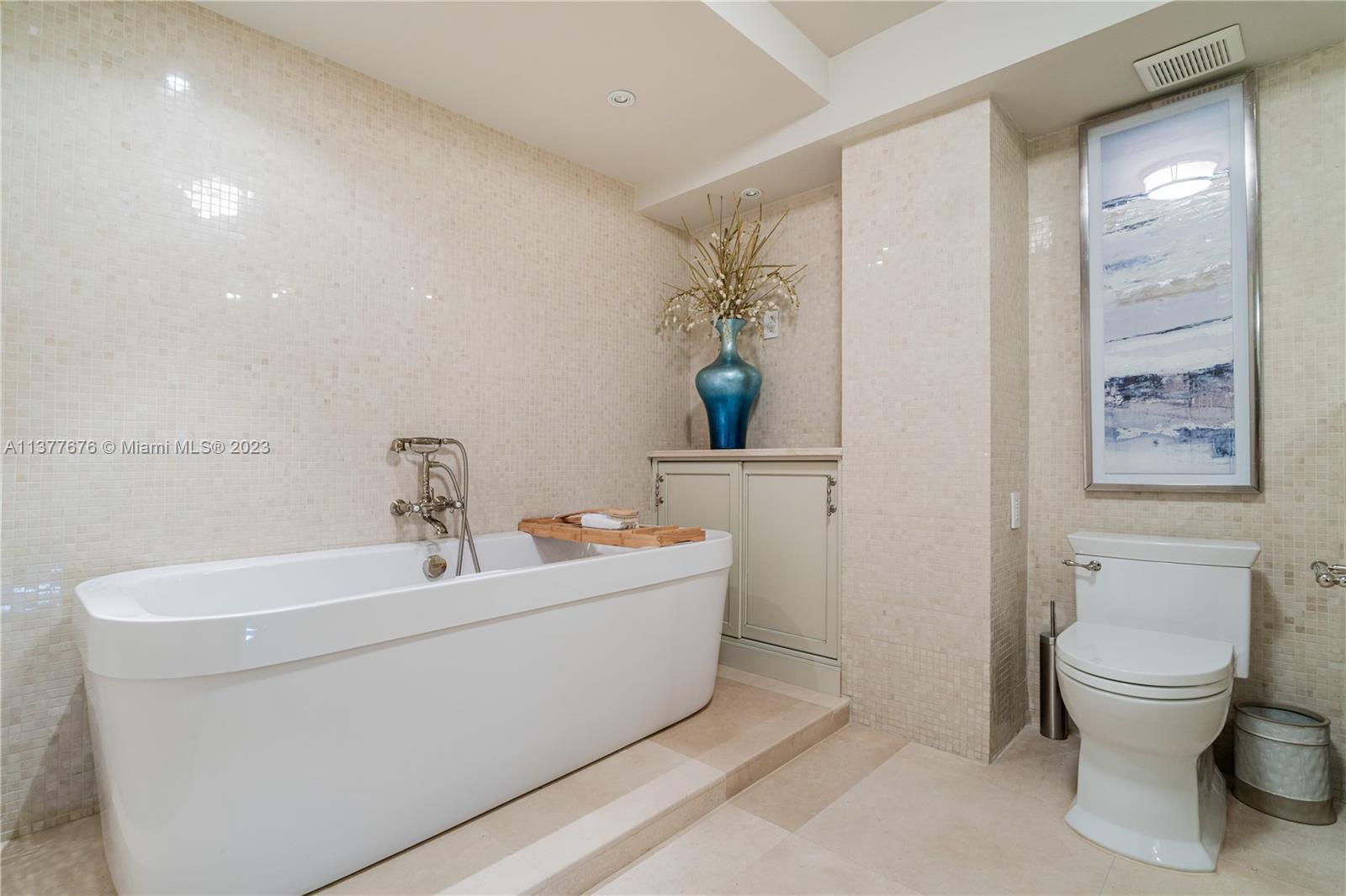 Stunning bathroom showcasing an elegant vanity area, free-standing Jacuzzi Tub, and oversized glass-enclosed Steam Shower.