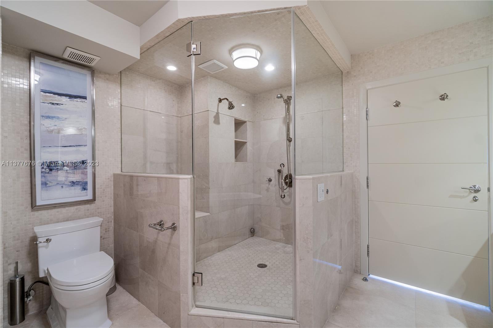 Stunning bathroom showcasing an elegant vanity area, free-standing Jacuzzi Tub, and oversized glass-enclosed Steam Shower.