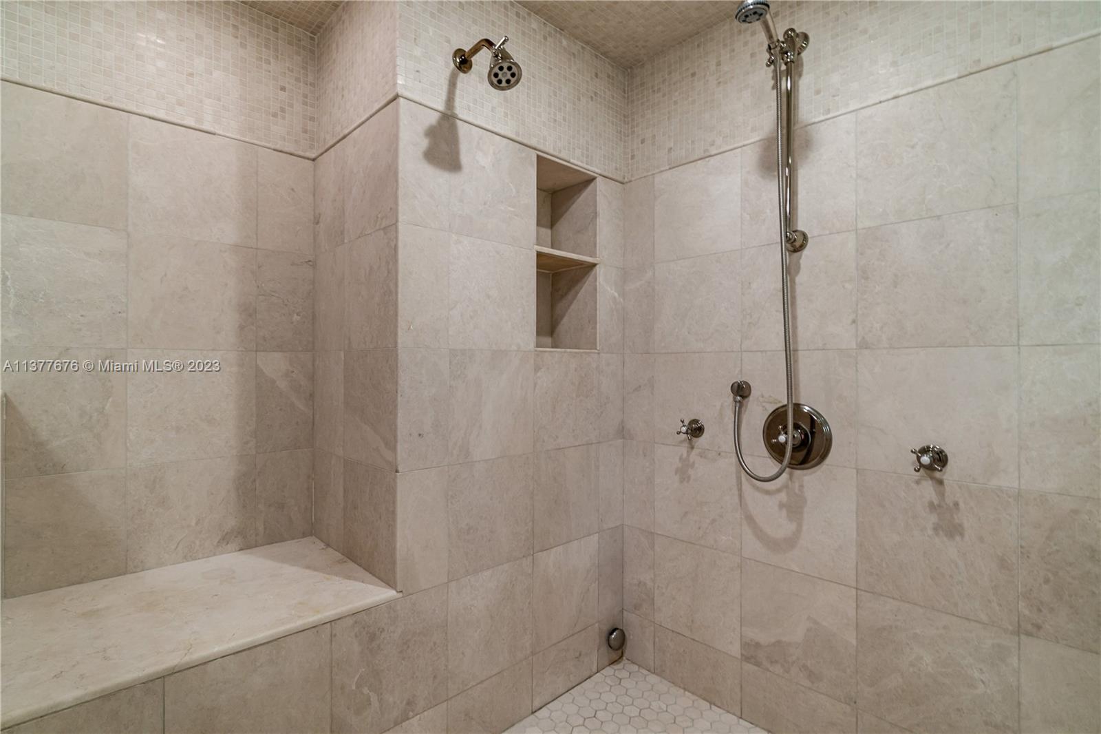 Stunning bathroom showcasing an elegant vanity area, free-standing Jacuzzi Tub, and oversized glass-enclosed Steam Shower.