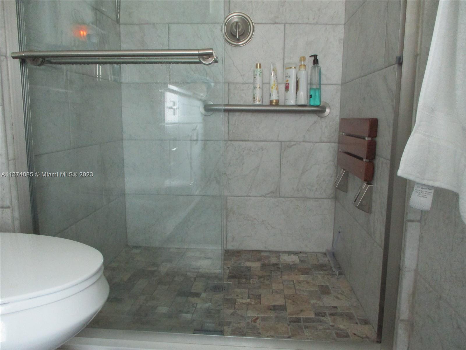 WALK-IN SHOWER WITH SLIDING GLASS DOORS, PULL OUT CHAIR