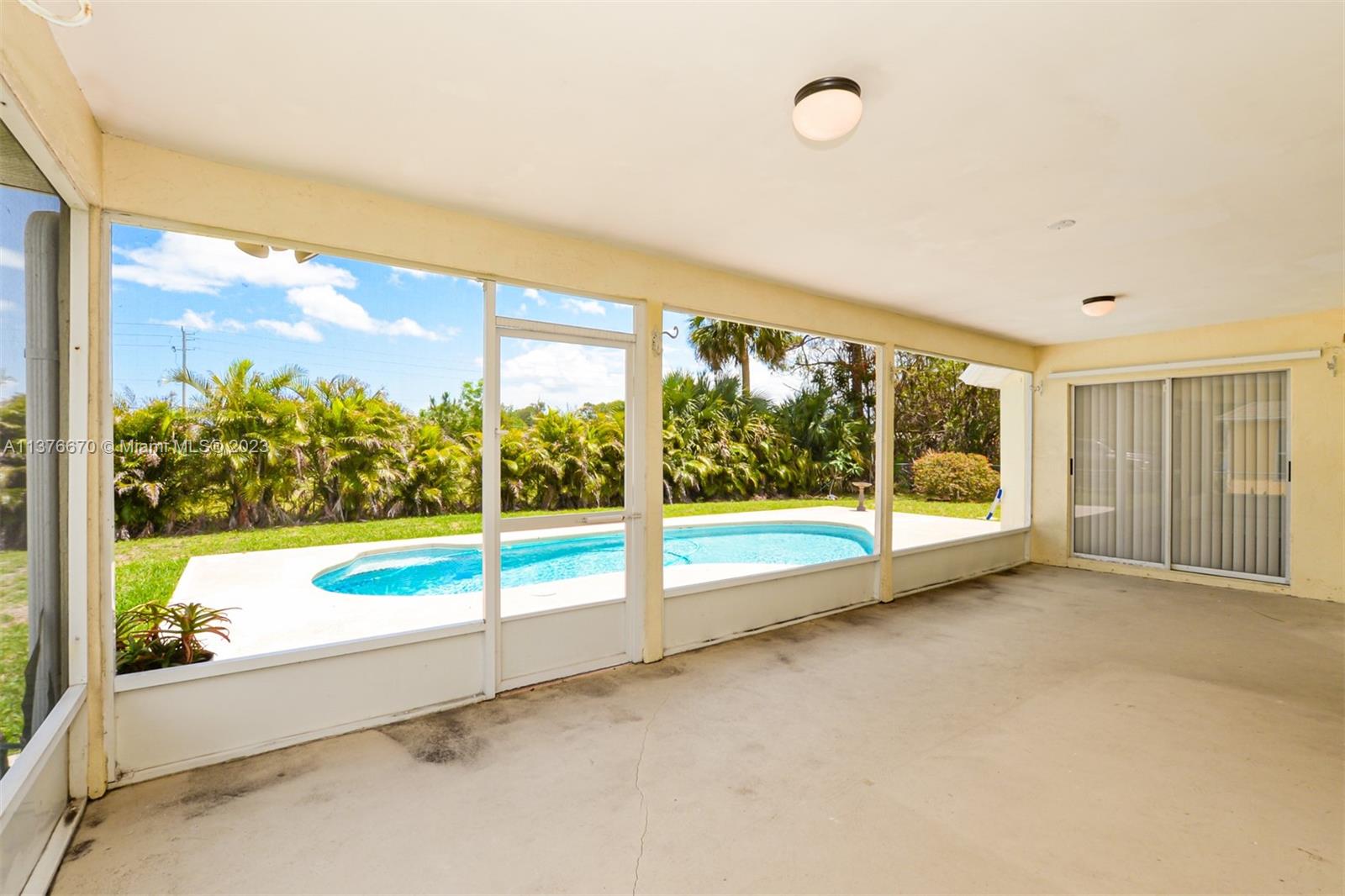 Large Florida room with beautiful pool and tropical landscaping views