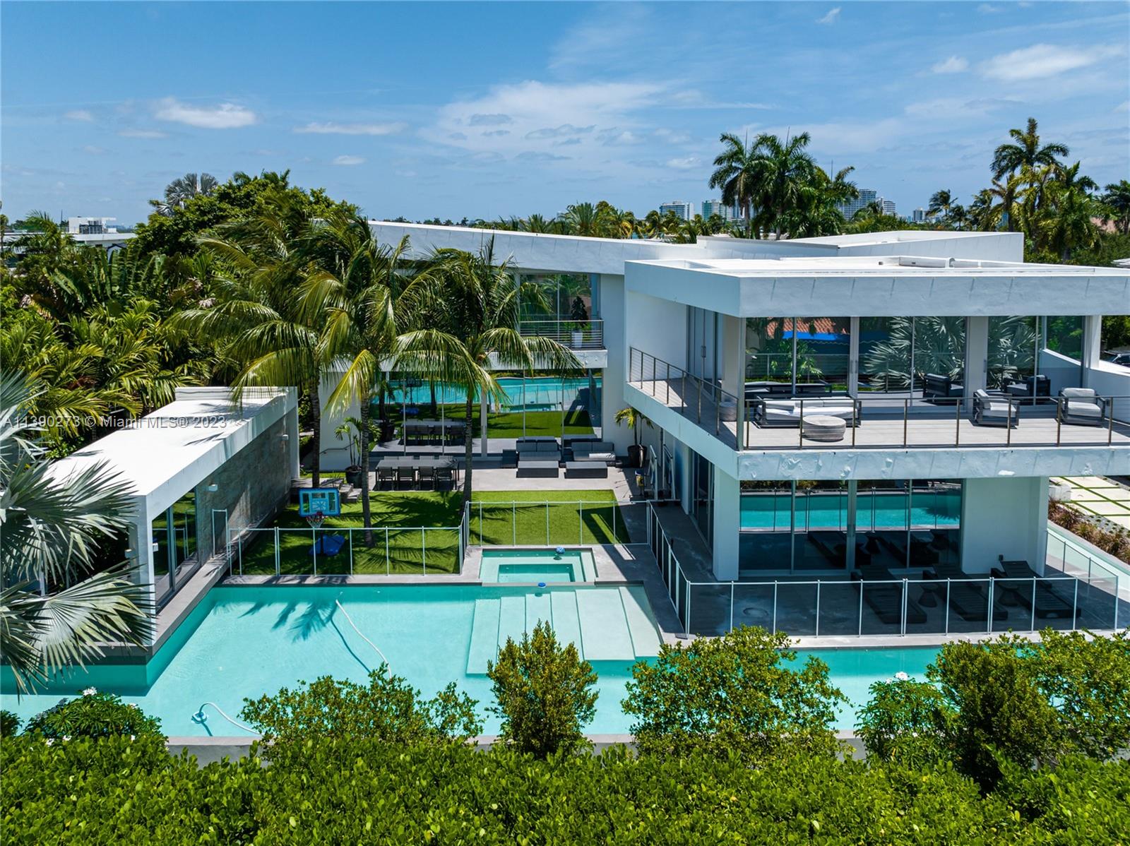 Exquisite modern residence on an extra large corner lot on Miami Beach's guard gated Hibiscus Island. Showcasing impeccable design & meticulous attention to detail, the open floor plan features soaring ceilings & panoramic doors to the exterior. Gourmet kitchen features Thermador + Wolf appliances & custom cabinetry. The primary suite is a serene oasis, featuring a spa-like ensuite bathroom & 2 spacious walk-in closets. Additional ensuite bedrooms  provide comfort & privacy. The outdoor living area is perfect for relaxation & entertainment, with a sparkling pool and plenty of space for lounging or dining al fresco.  Private guest house. Hibiscus Island offers a waterfront park, tennis & basketball courts, playgrounds & 24-hr police officer at the main entrance.