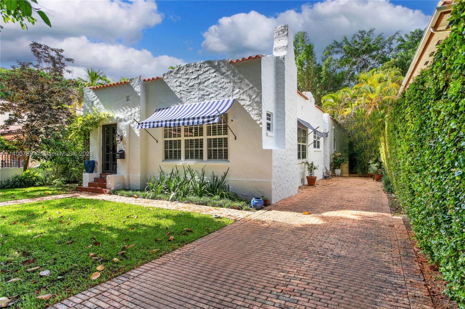 This exquisite Old Spanish home was built in 1923, then recently remodeled & expanded to bring modernity to the property while maintaining its original charm. A foyer entry w/ Cuban tile floors leads to the formal liv & din rooms featuring fireplace & Dade County Pine flrs.  The 2 BRs in the original portion of the home are generously sized & share a renovated BA.  Through a gracious office area you will find the chef’s kitchen w/ white cabinetry, marble counters, & Miele & Wolf appliances.  The kitchen opens to a spacious family rm w/ banks of French doors to the lush garden beyond.  The primary suite also opens to the garden & has a marble BA & walk-in closet. Other features incl Chicago brick patio, specimen trees, impact glass throughout, new a/c, & more in the heart of the Gables!