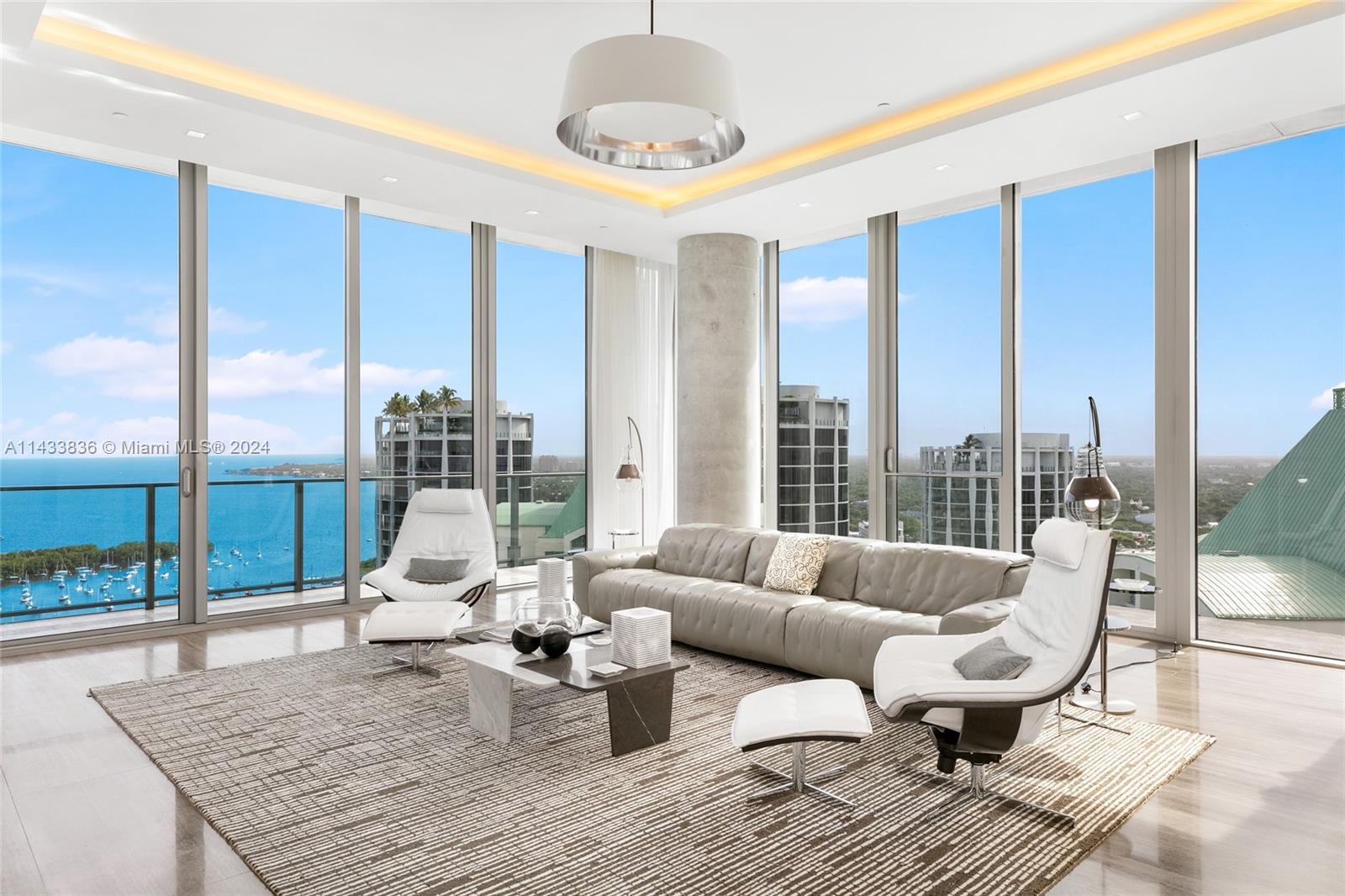 Discover Miami's grandest single-floor condo in Miami, spanning 11,000 sq. ft with 12' ceilings. This penthouse, designed by Nick Luaces, showcases 6 beds, 6 baths, 2 powder rooms, a theater, library, office, and distinct seating zones. Boasting Bang & Olufsen home automation, the 3,000 sq. ft master suite stuns with a chic dressing area, midnight kitchen, gym, sauna, and terraces accessible from public spaces. Move-in ready and fully furnished with remarkable artwork, this home includes access to a 4-car private garage with storage. Enjoy bay views from the unique wrap-around terrace, private elevator foyer, and deluxe kitchen.  This masterpiece resides in Grove at Grand Bay by architect Bjarke Engels. Experience an unparalleled lifestyle living in the heart of the Grove!