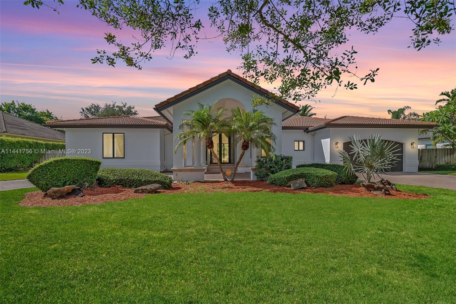 A Lush Tropical Residence! Inside, the home dazzles with its high-volume and tray ceilings, adorned with elegant crown moldings. Has an open-concept design offering lots of sunlight to shine throughout. The property includes thoughtful additions such as a separate laundry and storage room, seamlessly blends beauty and functionality creating a captivating ambiance. The lush landscaping envelops the property in a tropical paradise. A circular driveway leads to a two-car porte-cochere, ensuring both style and shelter. Ample space remains for the addition of a pool, allowing for the creation of a true oasis. And has a NEW, flooring, and impact windows throughout. Showing by appointment only!