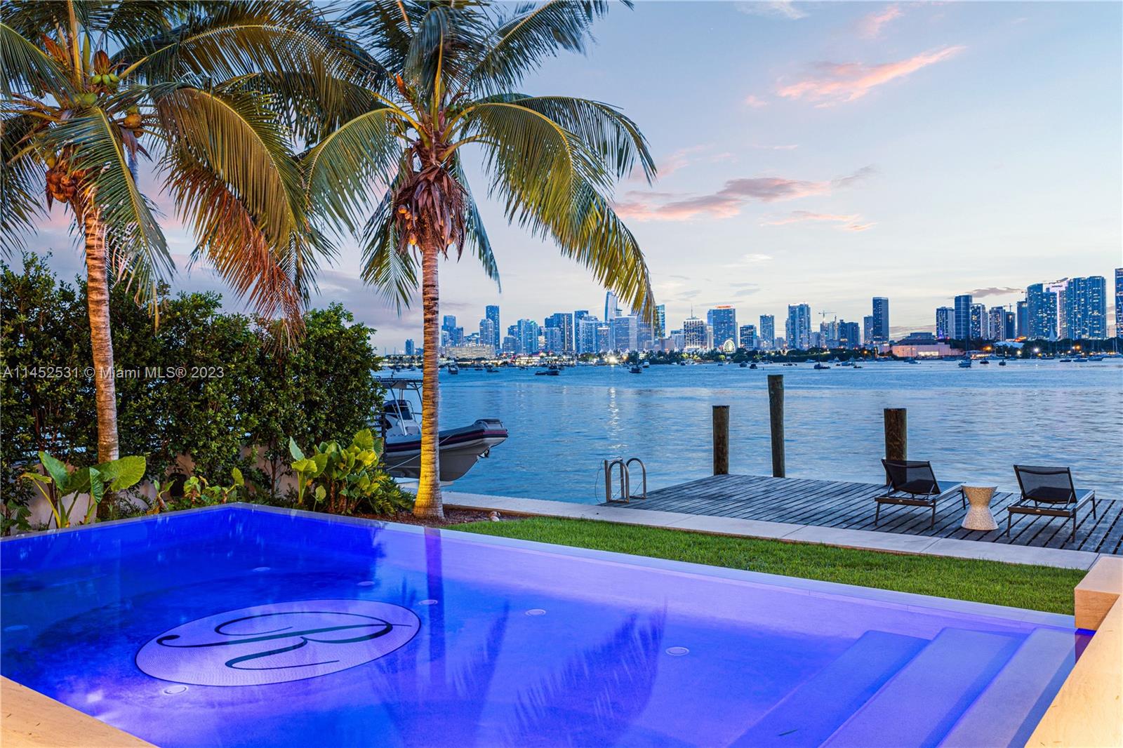 Enjoy unparalleled sunsets and envious Miami skyline views from this striking modern waterfront estate by Choeff Levy Fischman! Enter into a grand, double-height foyer leading directly into the bright open floor plan living area featuring sliding telescopic doors for seamless indoor/outdoor living. Expansive primary suite with an adjoining office overlooking the bay. White Oak floors throughout, rich millwork, and stunning book matched marble in the kitchen and primary bathroom. This entertainer’s paradise features a  covered summer kitchen, infinity pool, a dock with lift, and s rooftop terrace with endless 360 degree views.
