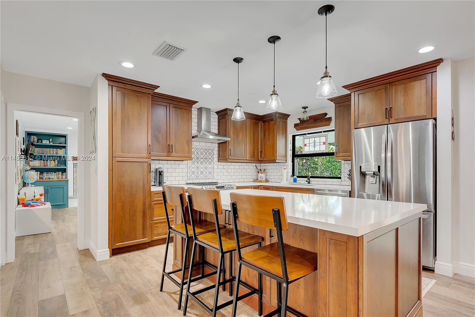 Remodeled, modern farmhouse style, 4 bdrm/ 2.5 bath home in Palmetto Bay. Spacious, open concept living area including formal living room, formal dining room and kitchen with warm wood cabinetry, subway tile, quartz countertops, stainless appliances, pantry & eat in snack bar. Fantastic natural light throughout. Wood plank-style tile flooring. Family room w/ mosaic & shiplap fireplace, charming bookcases, wet bar w/ wine cooler; built in desk. Indoor laundry rm w/ sink and folding area. Serene primary suite w/ pool views, walk in closet, primary bath has separate soaking tub and shower, dual sink. Deep covered patio w/ pool & play area. Side entry garage w/ storage loft. Circular driveway.  Newer roof. Updated plumbing, impact windows/doors. Fenced backyard with lovely Oak tree canopy.