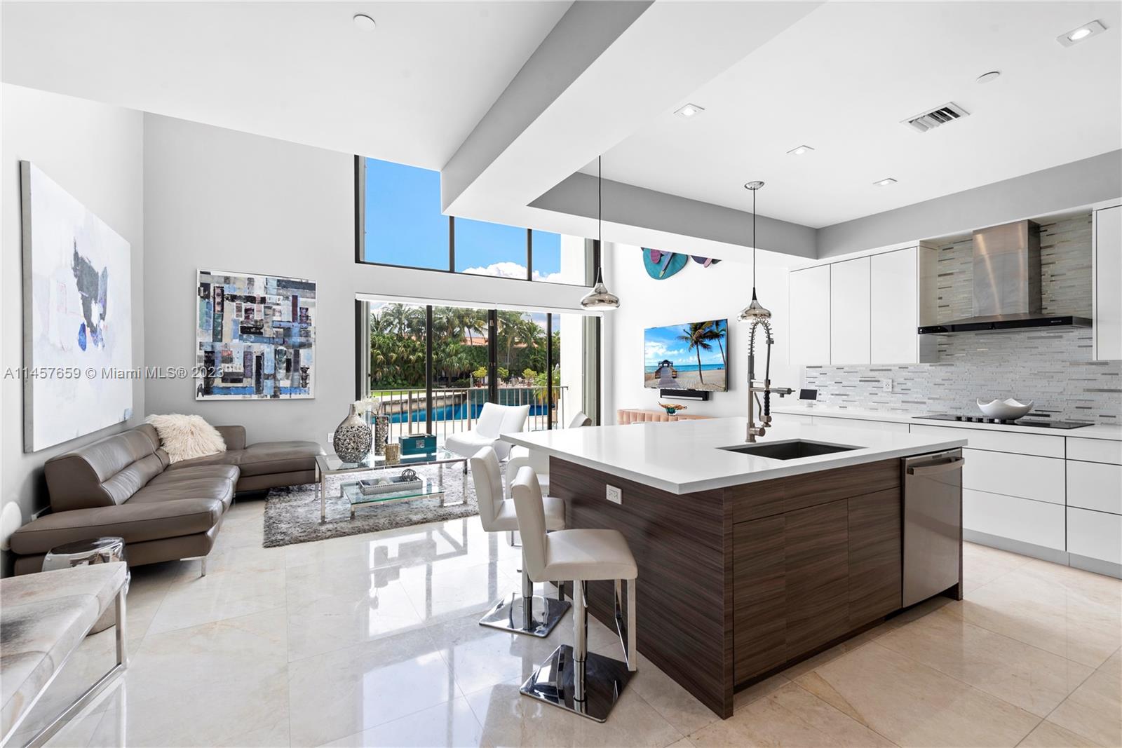 Discover a hidden enclave of 40 townhouses reminiscent of a small European village within easy reach of Miami Beach, Aventura, and Downtown Miami. This 4-story townhouse in Quayside, a gated bayfront community, boasts a private elevator. With over 4800 sqft of renovated living space, it features marble and wood flooring, a modern kitchen, and a full-floor master suite with downtown Miami skyline views. This luxury residence offers 4 bedrooms with ensuite bathrooms, a home theater, custom bar/lounge area, a glass-encased wine closet, and Sonos music system. Quayside, spanning 20+ acres, offers a full-service spa, pools, tennis courts, restaurants, and a marina. Enjoy contemporary design and outstanding community amenities for the ultimate Miami lifestyle.