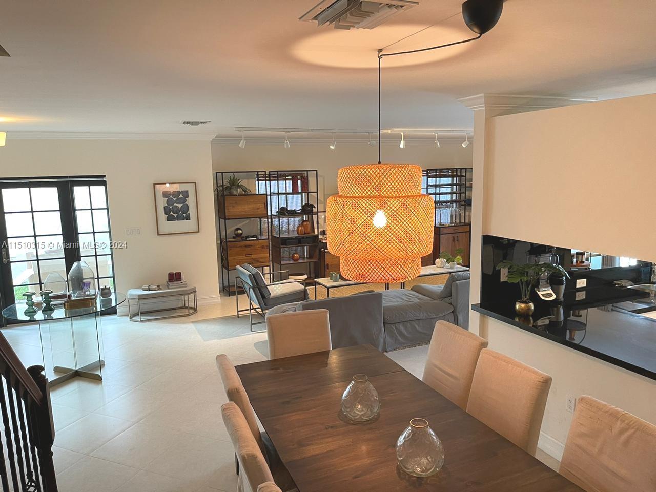 Dining area in the foreground with the front door to the left and the living room to the right.