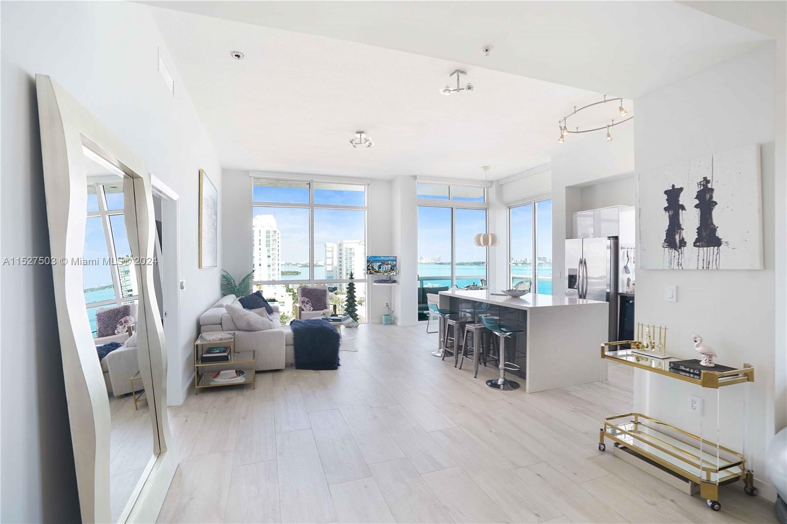 Stunning PH at 360 Condo in North Bay Village! Enjoy sweeping views of the bay and ocean from this 1,552SF unit with 11' ceilings and high impact floor to ceiling windows. This spacious condo was originally designed as a 3 bedroom floor plan but it currently has 2 enclosed bedrooms and the 3rd one is open allowing for an office, formal dining or open den space. It can easily be converted into a 3 bedroom condo. It boasts a designer kitchen and bathrooms with wood-look porcelain tile throughout, designer lighting, a Nest climate system and motorized blinds. The master bathroom offers a marble stand in shower and a Roman jacuzzi tub. 360 Condo offers a gated community with private security, a private marina, 2 heated pools, fitness center, valet, 24hr concierge, EV charging stations + more!