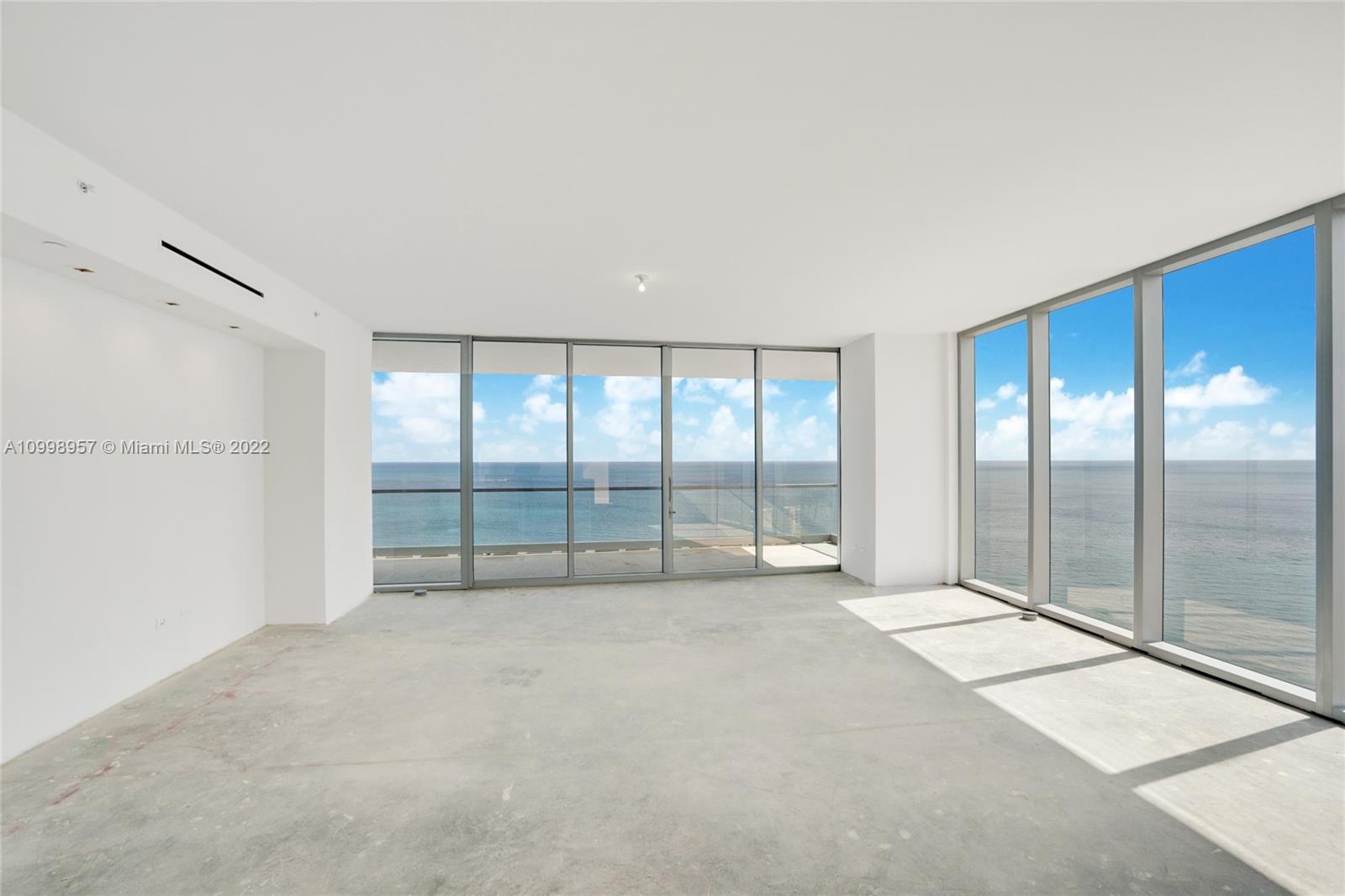 Living room area with many windows looking the Ocean