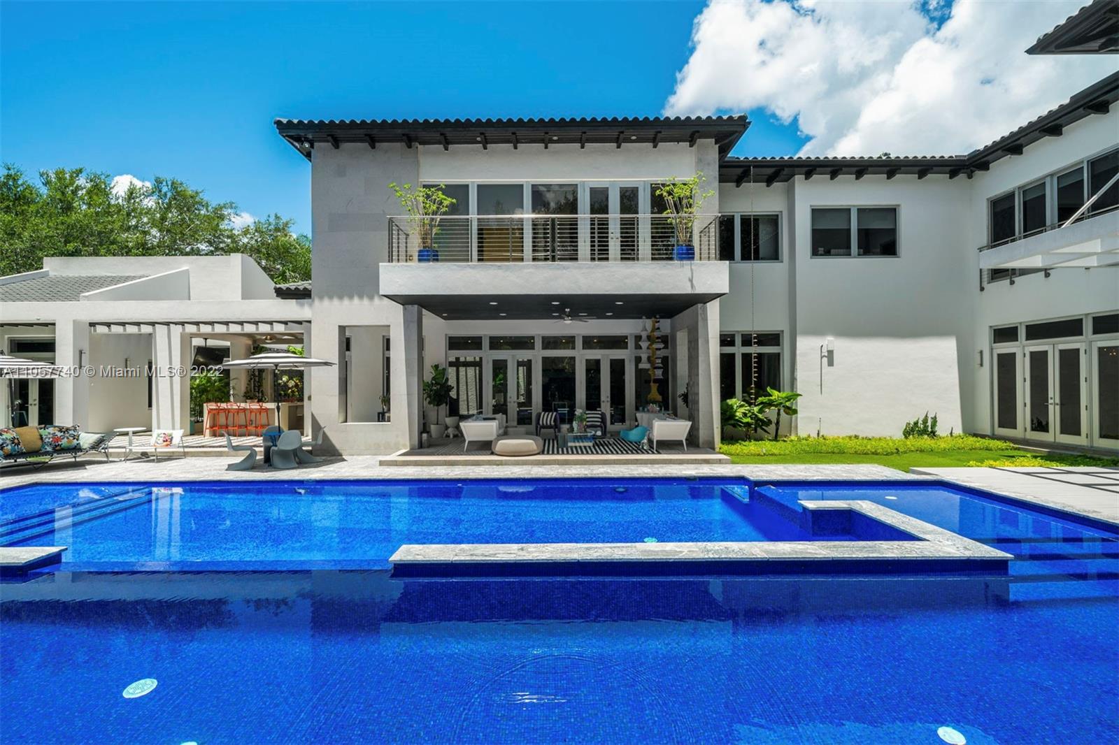 Glamorous contemporary living in Ponce Davis. This 10,267 Sq. Ft. home, with 7 bedrooms, 7 full and 2 half bathrooms, features open balconies throughout the second floor, high ceilings, tall windows, and French doors allowing seamless integration of the indoor living spaces and outdoor terraces. State-of-the-art floor plan includes an open family room and beautifully appointed chef’s kitchen with Miele and Gaggenau appliances. The main suite, with seating and an office area overlooking the gardens, has a sumptuous spa-like bathroom. Superbly designed and manicured grounds include a sparkling pool with wave pump, covered terraces ideal for entertaining, full summer kitchen, and separate fitness room. This magnificent home balances style and comfort, perfect for today’s lifestyle.