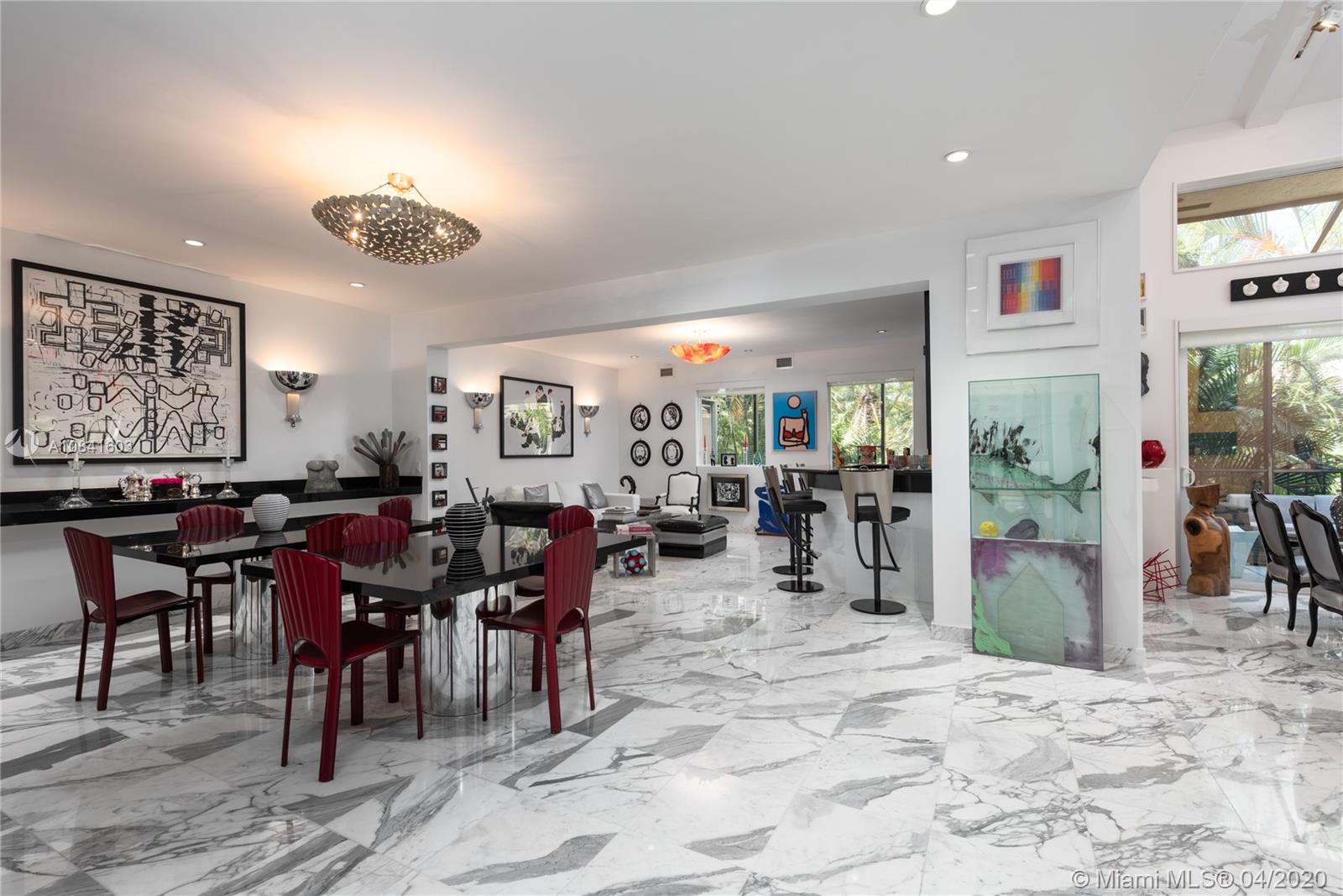 Glamorous corner villa is artistically designed with sleek and modern touches that include marble floors and stainless steel staircase. Light-filled main living area features wall of custom windows and added family room with granite wet bar. Master bath includes spacious dressing room, 4 walk-in closets, and Italian storage system. Beautiful outside patio where you can enjoy a barbecue &  a cozy outdoor seating area. You can even have a peak at the ocean! There is a steam room in the ground floor, impact resistant windows throughout, 3 AC zones and a garage that has been converted into a gym. Perfect for the Art lover and great for entertaining! Exclusive gated community on Biscayne Bay, walking distance to parks, Coral Reef Sailing Club and a few min from Brickell & Downtown!
